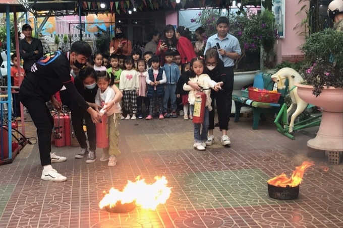 Các em học sinh được thực hành kỹ năng sử dụng bình chữa cháy xách tay.