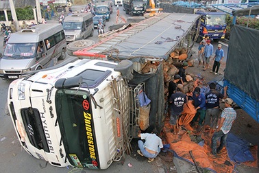 Lật xe tải, 20 tấn gỗ tràn xuống đường