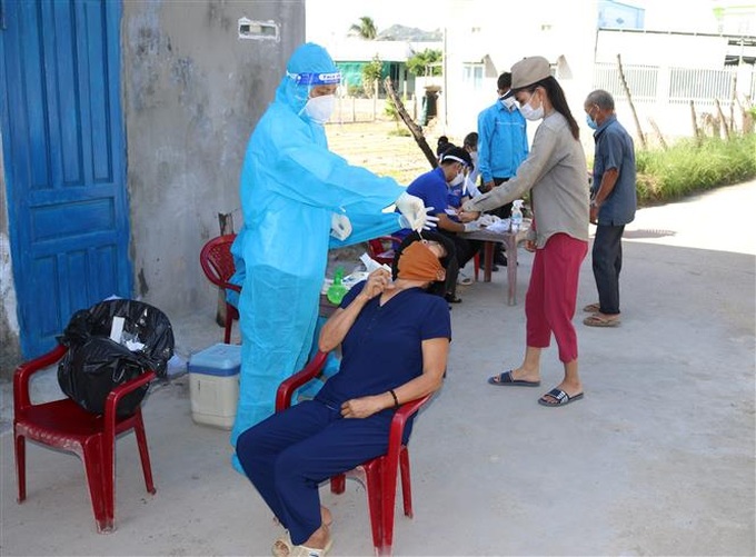 Lực lượng y tế triển khai lấy mẫu tầm soát xét nghiệm virus SARS-CoV-2. Ảnh: Nguyễn Thành - TTXVN.