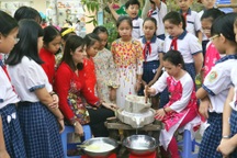 Hàng trăm học sinh tiểu học hào hứng học xay bột, gói bánh tét ăn Tết