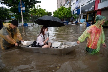 Người và xe "bơi" trong dòng nước ngập sâu ở Hà Nội