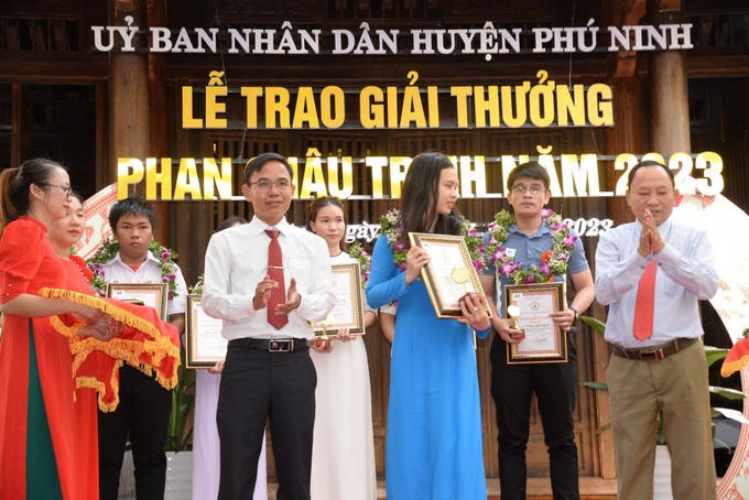 Bí thư Huyện ủy Vũ Văn Thẩm (phải) và Chủ tịch UBND huyện Phú Ninh Huỳnh Xuân Chính trao giải thưởng Phan Châu Trinh cho các học sinh, sinh viên có thành tích xuất sắc trong học tập