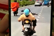 Người đàn ông khuyết tật nằm ngửa trên xe máy di chuyển ở Bình Dương