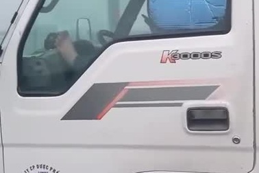 Tài xế vừa nằm gác chân, vừa sử dụng điện thoại khi đang lái xe tải