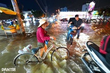 Cụ bà bì bõm dắt xe về nhà trong đêm ngập do triều cường ở TPHCM