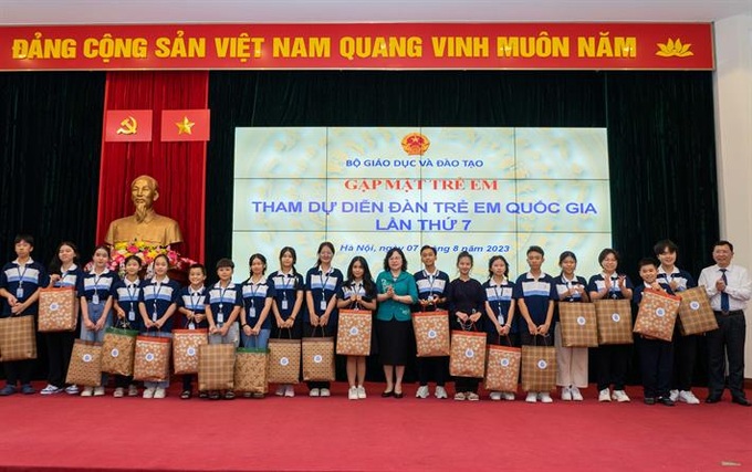 Thứ trưởng Bộ GD&ĐT Ngô Thị Minh trao quà và chụp ảnh lưu niệm cùng đại diện các em học sinh tham dự Diễn đàn Trẻ em quốc gia 2023.