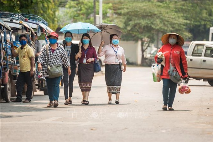 Người dân đeo khẩu trang phòng lây nhiễm COVID-19 tại Viêng chăn, Lào, ngày 23/3/2020. Ảnh: THX/TTXVN