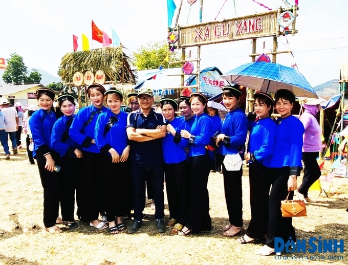 Thiếu nữ trong trang phục truyền thống chụp hình lưu niệm cùng du khách