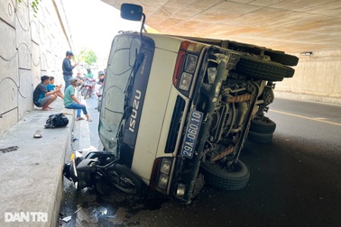 Ô tô tải biển xanh đi vào đường cấm, lật đè 2 xe máy ở TPHCM