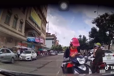 Dừng xe máy giữa đường nhắn tin, cô gái nổi xung khi tài xế ô tô nhắc nhở