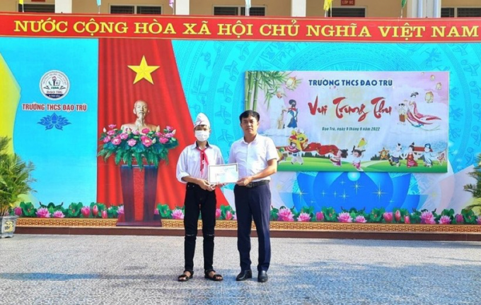 Em Đinh Công Sơn nhận phần thưởng động viên từ Hiệu trưởng Lê Mạnh Quỳnh.