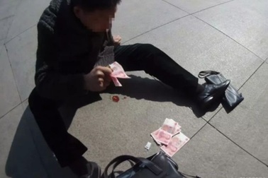 Người đàn ông ném tiền ra đường để cầu cứu