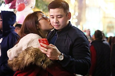 Các cặp đôi trẻ tay trong tay ấm áp đêm Giáng sinh