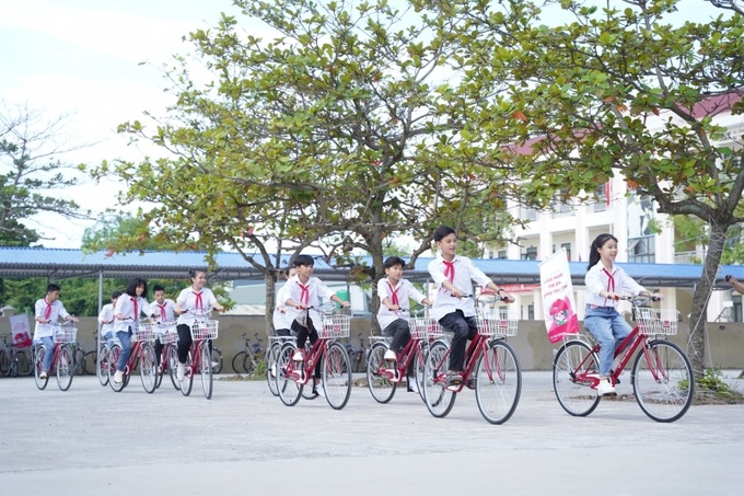 Trẻ em nhận xe đạp.