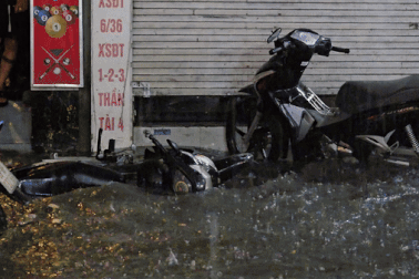 Nước tràn vào nhà xối xả, xe máy nổi lềnh bềnh trong cơn mưa lớn ở Hà Nội