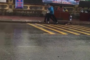 Xúc động clip nữ tình nguyện viên chạy hộc tốc che ô cho thí sinh đi muộn