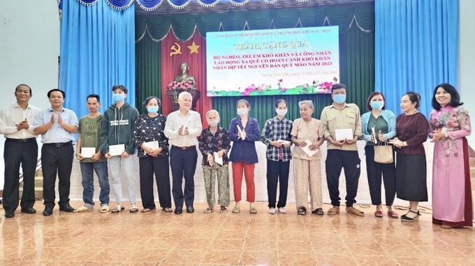 Bí thư Tỉnh ủy Nguyễn Văn Lợi (thứ sáu từ trái qua) cùng ông Trịnh Đức Tài – GĐ Sở LĐ-TB&XH tỉnh Bình Dương tặng quà tết cho các đối tượng có hoàn cảnh khó khăn.