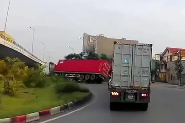 Bất cẩn khi vào cua, xe công-ten-nơ lật nghiêng, suýt đè người đi đường