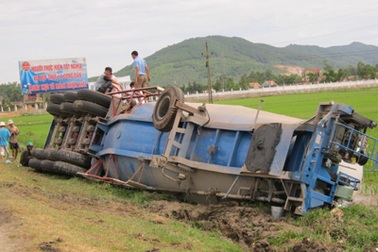 Chạy quá nhanh, xe rơ-moóc lật ngửa ra ruộng 