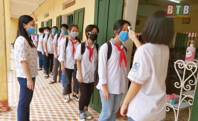 Đo thân nhiệt cho học sinh trước khi vào lớp.