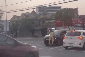 Ô tô lao nhanh khi một cảnh sát giao thông bám trên nắp capo