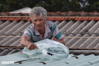 Người dân miền Trung bơm nước, xúc cát lên mái nhà chống bão Kalmaegi