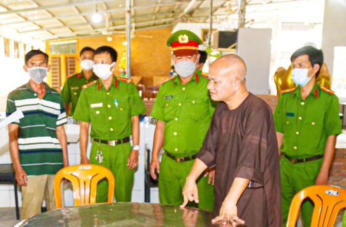 Lực lượng chức năng tống đạt các quyết định khởi tố, bắt tạm giam đối với Hồ Hữu Phúc (áo nâu).
