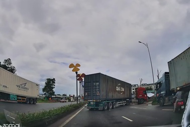 Người đi xe máy liều lĩnh lách vào khoảng trống sau xe container đang lùi