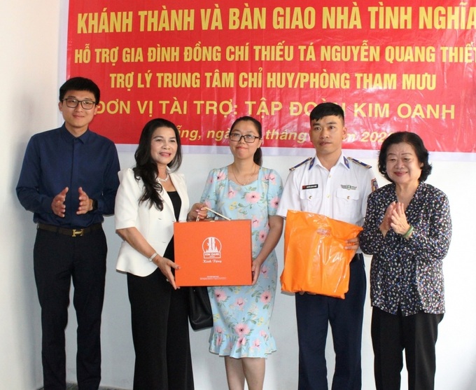 Bà Trương Mỹ Hoa và bà Đặng Thị Kim Oanh tặng món quà nhỏ chúc mừng tân gia đến gia đình Thiếu tá Thiết.