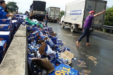 Người dân giúp tài xế thu gom gần trăm thùng bia đổ trên cầu