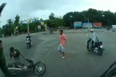 Áo mưa quấn vào bánh xe quật người đi xe máy ngã nhào xuống đường