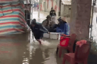 Mưa lớn gây ngập đường, gia chủ dùng xe kéo chở khách vào ăn cỗ cưới