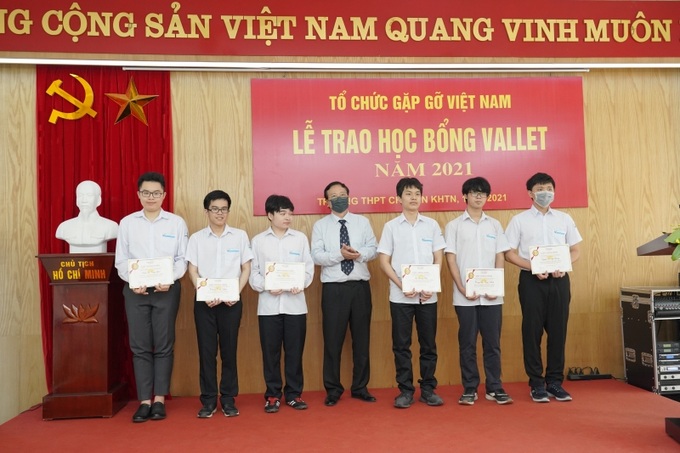 Ông Vũ Văn Thịnh, Giám đốc Công ty TNHH Tư vấn và Đào tạo HMT, thành viên Ban tổ chức quỹ học bổng Vallet (đứng giữa) trao học bổng cho các em học sinh Trường THPT Chuyên KHTN đạt huy chương Olympic quốc tế.