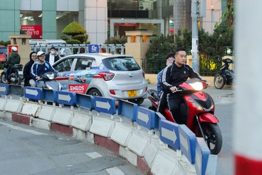 Phụ huynh đi xe máy chở trẻ nhỏ vẫn vô tư vượt đèn đỏ ở Hà Nội