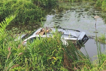 Ô tô đang đậu bên đường bị tông văng xuống ao