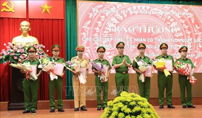 Trung tướng Nguyễn Duy Ngọc, Ủy viên Ban Chấp hành Trung ương Đảng, Thứ trưởng Bộ Công an trao thư khen, tặng hoa chúc mừng các tập thể, cá nhân tham gia chuyên án.( ảnh TTXVN)