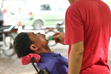 Tranh thủ cắt tóc, cạo râu trong lúc chờ con đi thi