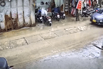 Cầm ô đi xe máy, người đàn ông lao thẳng vào ô tô