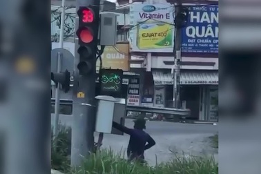 Người đàn ông mặc thường phục bấm đèn giao thông ở TPHCM