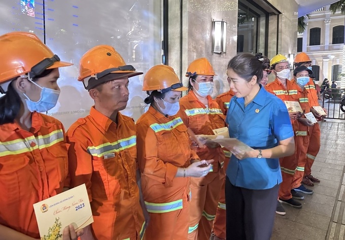 Bà Trương Thị Minh Dung, Chủ tịch Liên đoàn Lao động Quận 1 chúc Tết công nhân trực Đường hoa Nguyễn Huệ trong tối 30 Tết. Ảnh: VGP