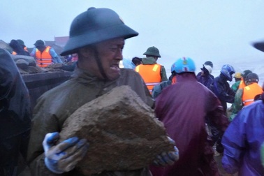 Hàng trăm người đội mưa, vật lộn với sóng dữ "vá" kè biển trong bão Bualoi