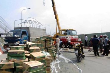 Xe tải lật, hàng trăm thùng sữa tươi rải đầy đường