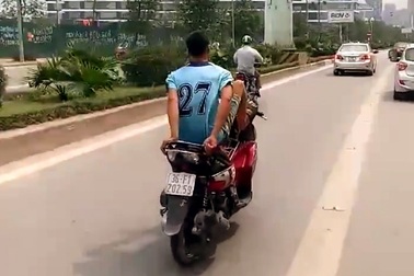 Nam thanh niên lái xe máy bằng chân trên làn đường buýt nhanh