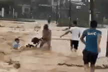 Thót tim cảnh 4 người cố níu chiếc xe máy bị lũ cuốn trôi