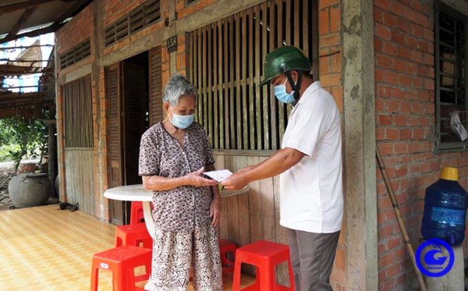 Cán bộ địa phương tỉnh Tiền Giang đến từng nhà trao tiền hỗ trợ cho người dân.