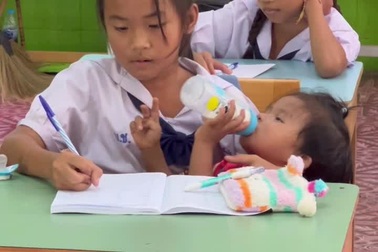 Bé gái vừa trông em vừa ngồi học trên lớp gây sốt mạng xã hội