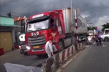 Người đàn ông đi xe máy liều mạng luồn lách cắt ngang đầu xe container