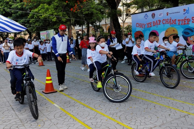 Các em học sinh thi chạy xe đạp chậm tiếp sức.