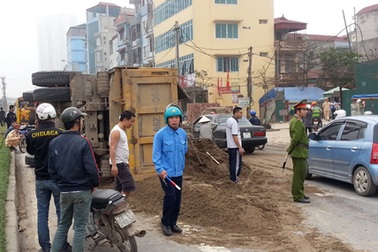 Xe tải chở cát lật nghiêng giữa đường