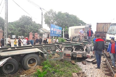 Dừng giữa đường ray, xe container bị tàu hàng đâm trúng